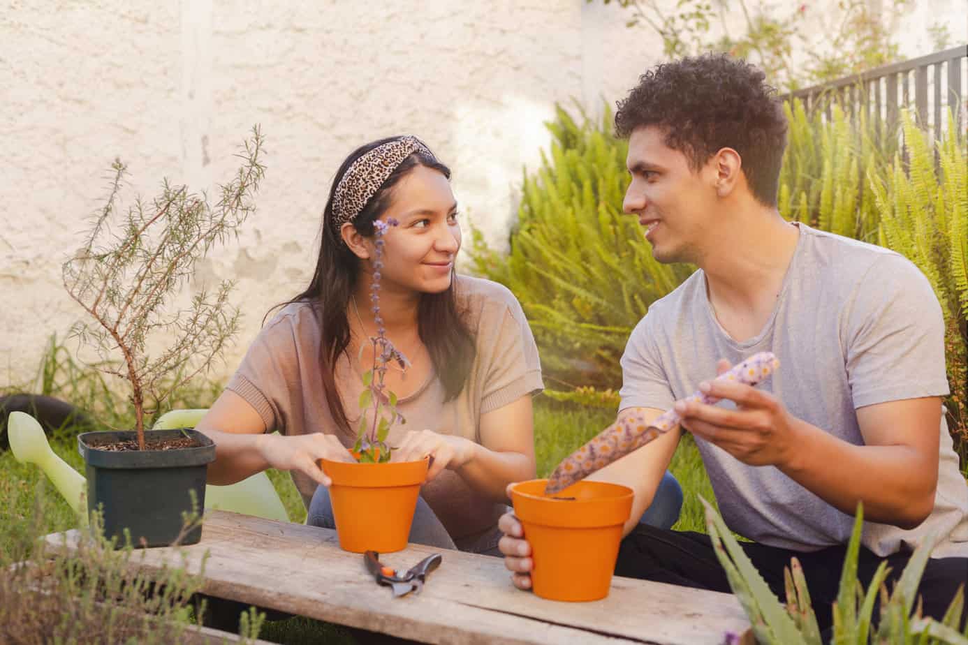 man and woman enjoy gardening and potting plants on patio