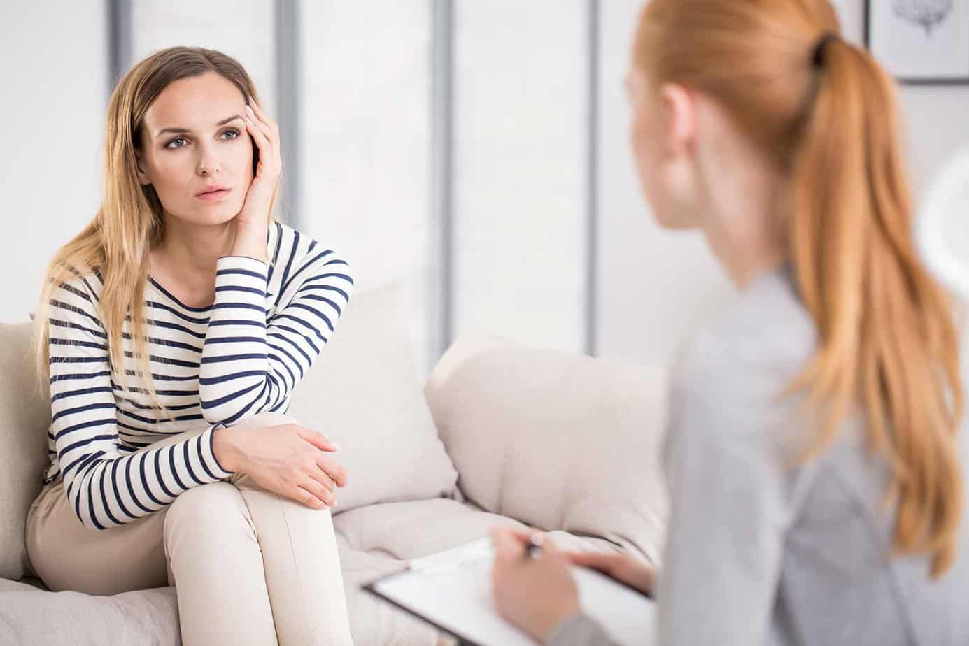 Woman in a striped shirt meeting with a psychiatrist for a psychiatric evaluation
