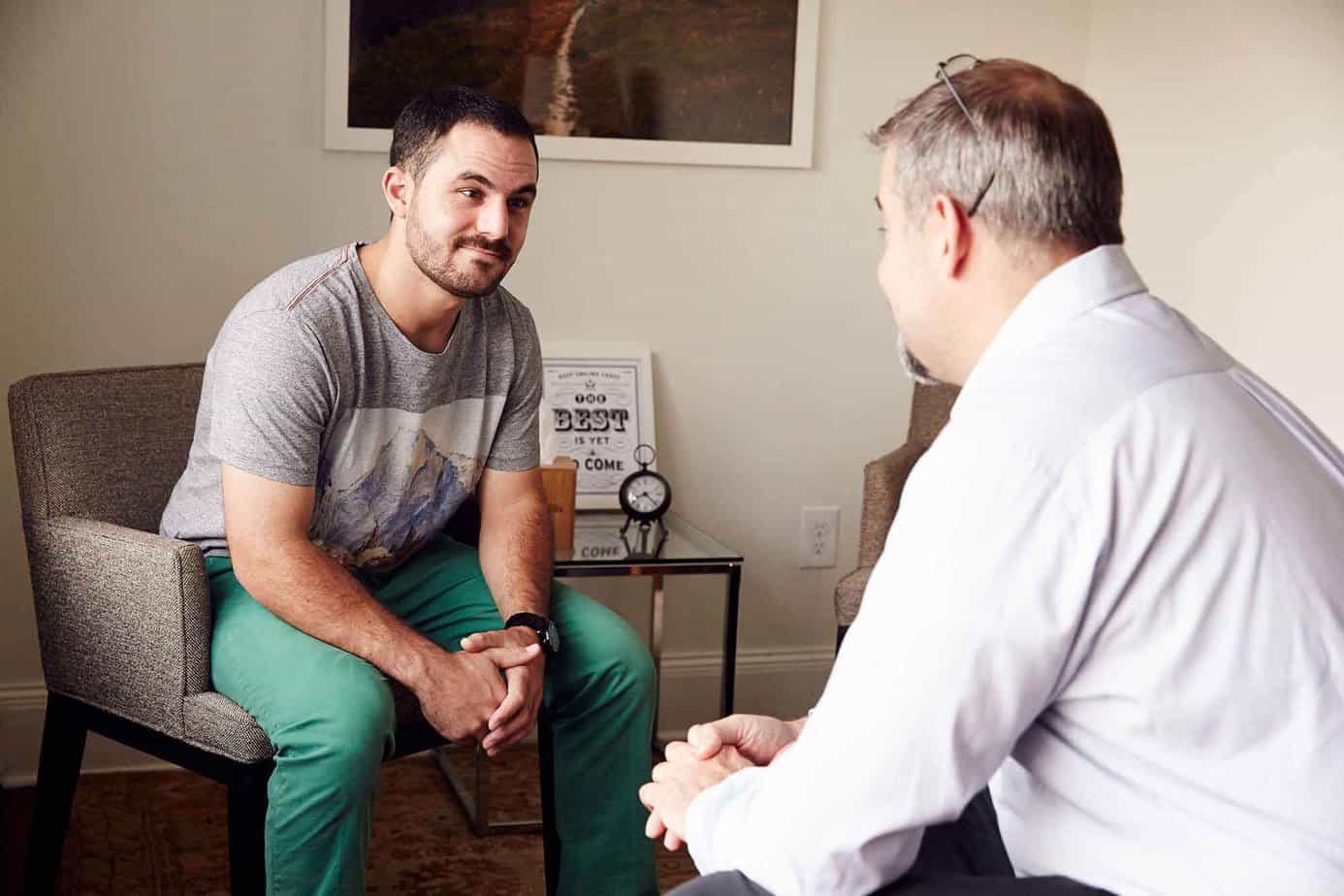 Male client and male clinician in an individual drug addiction treatment counseling session