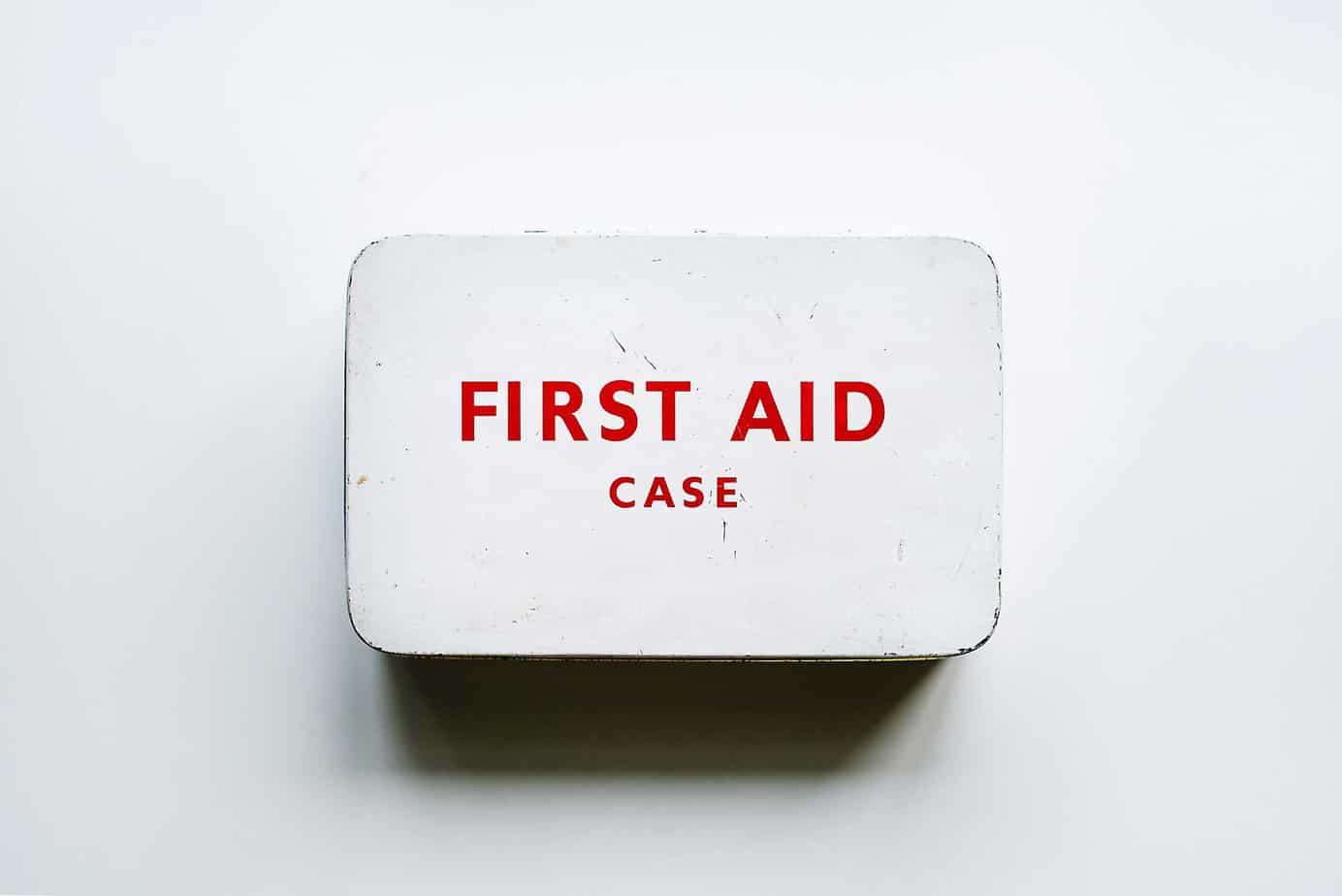 White Metal Tin with "First Aid Case" painted on top