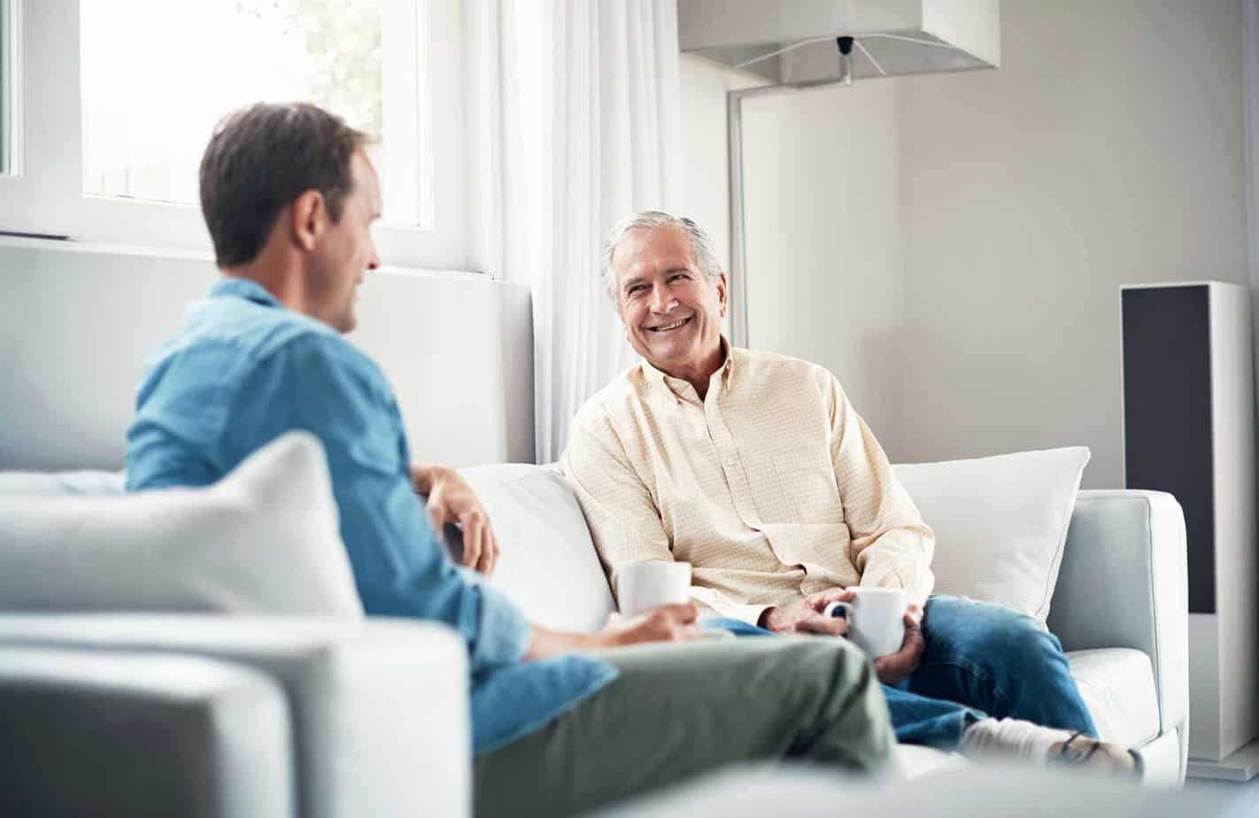 father and son having important conversation on couch in living room