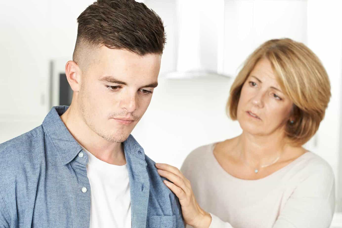 teenage boy struggling with addiction being supported by mother