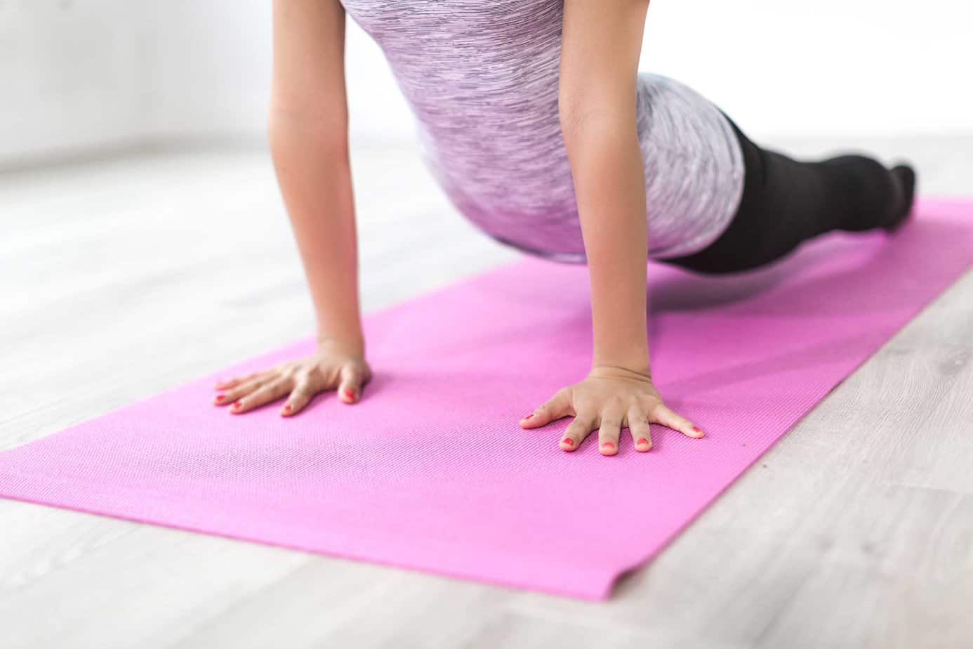 woman stretching and doing yoga on pink mat