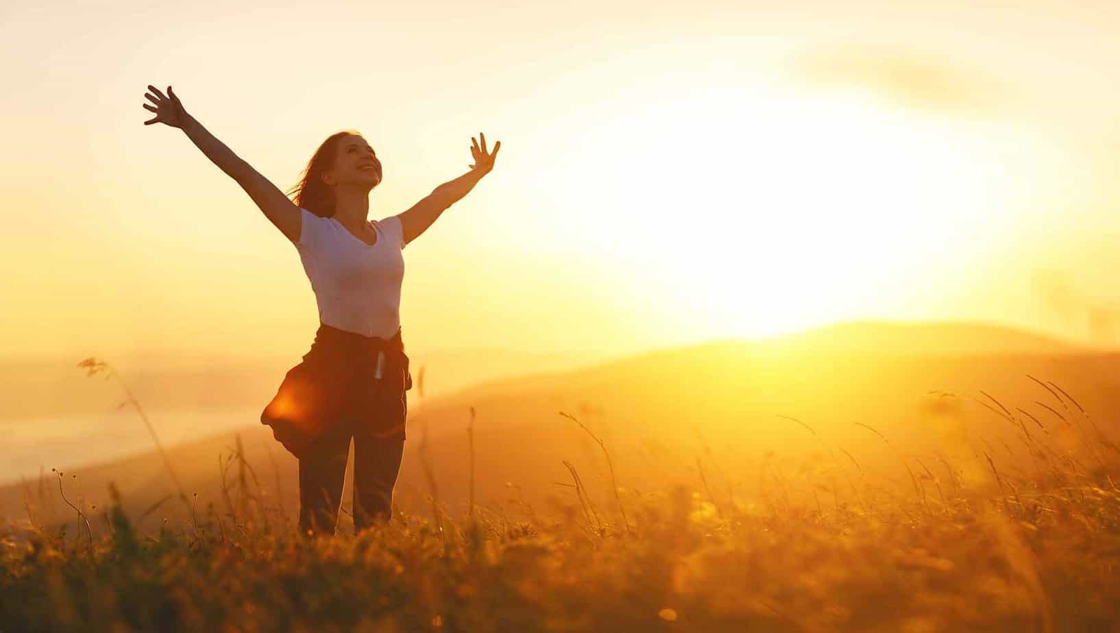 women celebrating recovery standing in the middle of empty field with sunset