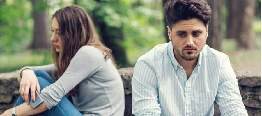 couple sitting outside looking away from each other after an argument