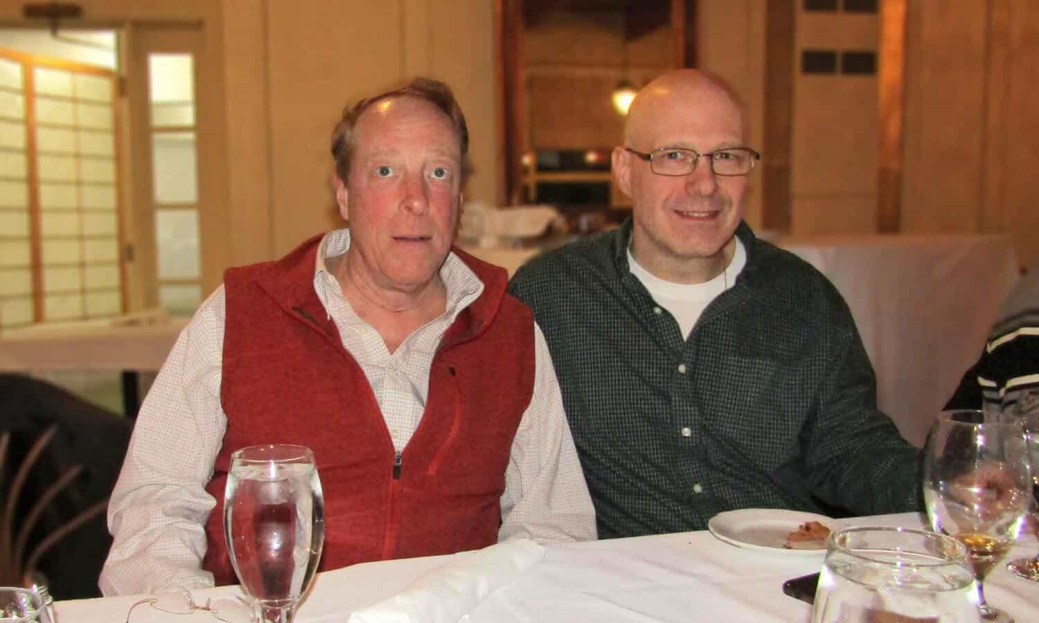 2 men smiling around a table at Mountainside Treatment Center Alumni Dinner and Roundtable in Connecticut