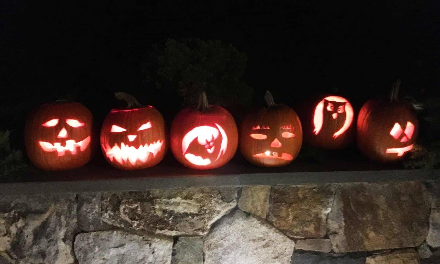 Jack-o-lanterns on stone wall at Mountainside Treatment Center Alumni Pumpkin and Pizza event