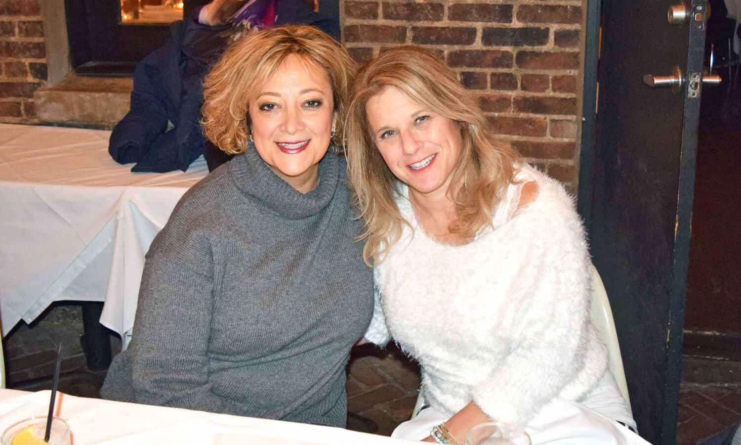 2 women smiling around a table at Mountainside Treatment Center Alumni Dinner and Roundtable in NYC