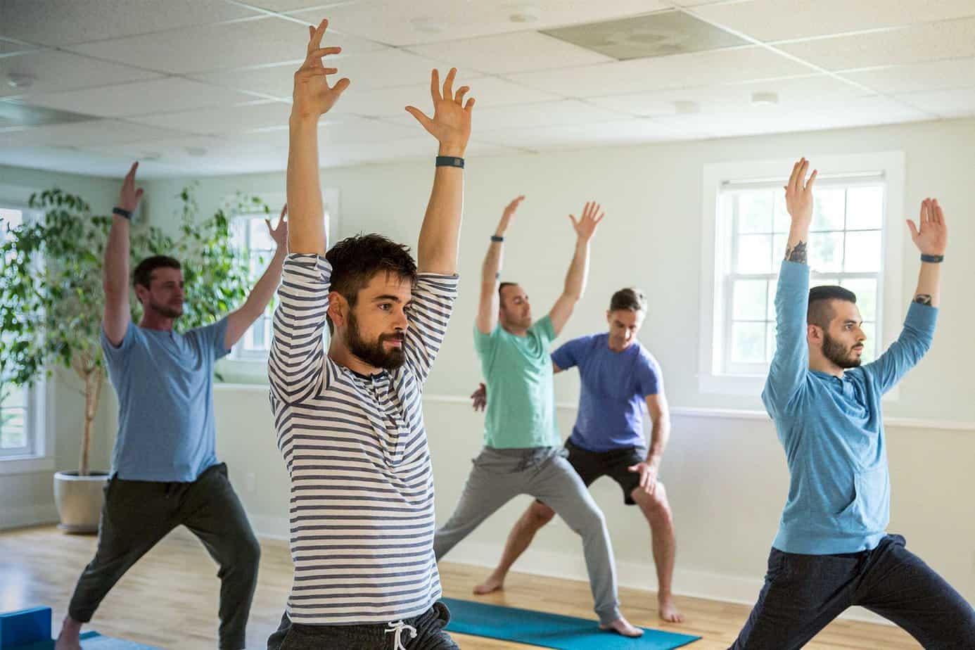 A group of men take a yoga class in bright room at Mountainside treatment center in Connecticut.