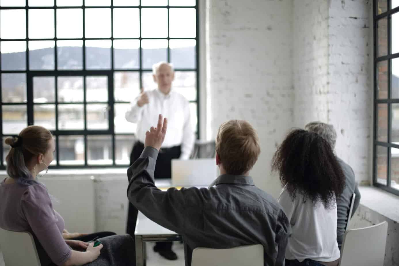 Person raising hand to ask a question in a meeting or seminar.