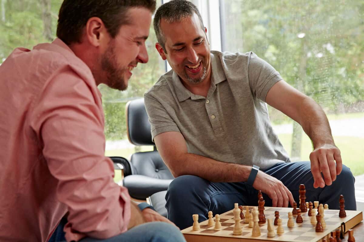 Two men in Mountainside's extended care sober living program playing chess together