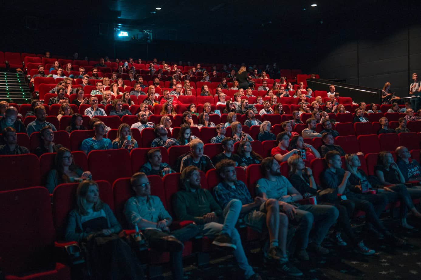 A group of people in a movie theater look up at the big screen