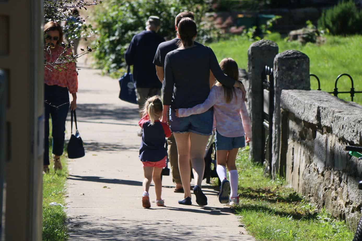 family walking together on sidewalk