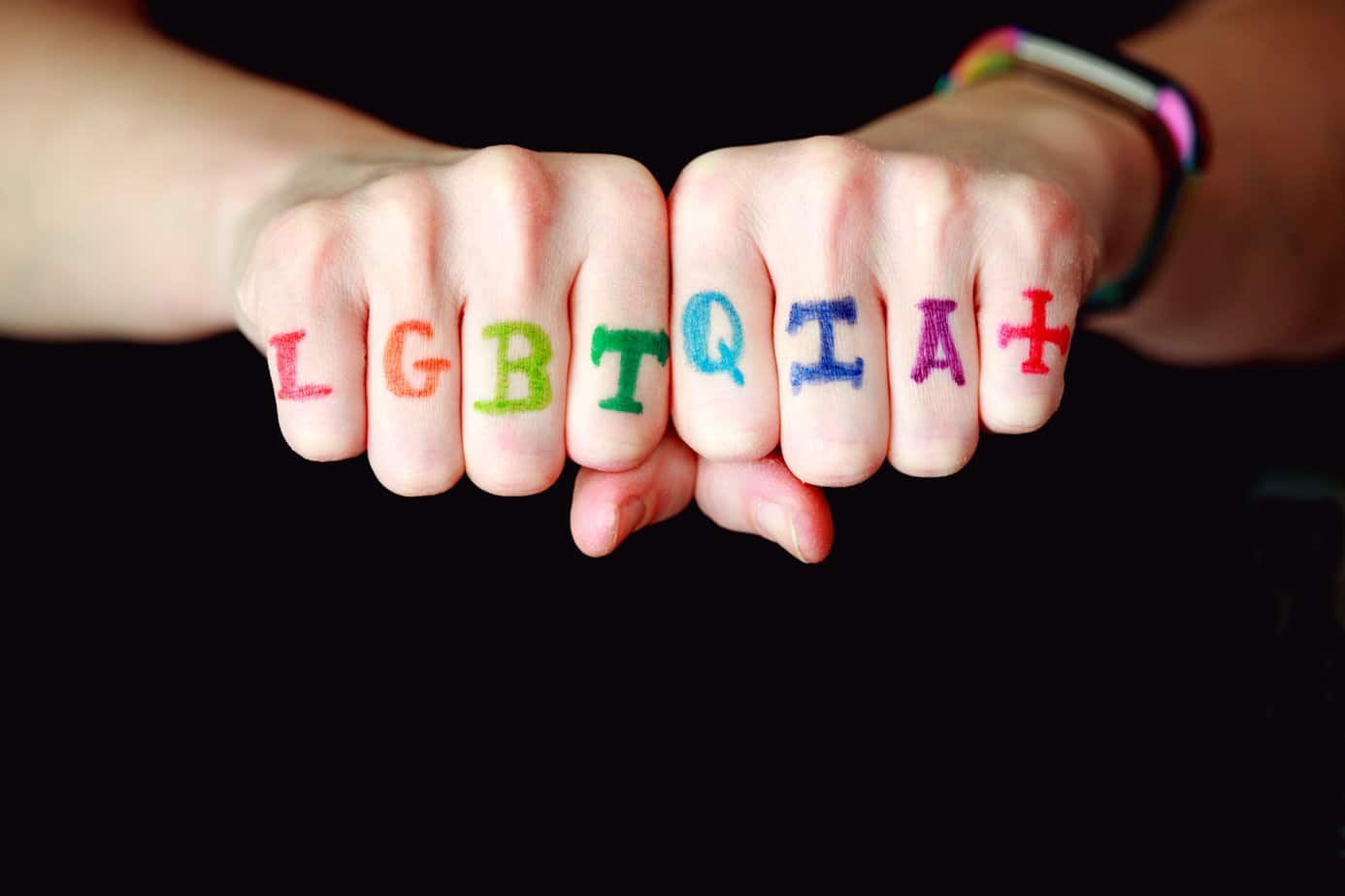 LGBTQIA+ handwriting on knuckles to represent the queer community