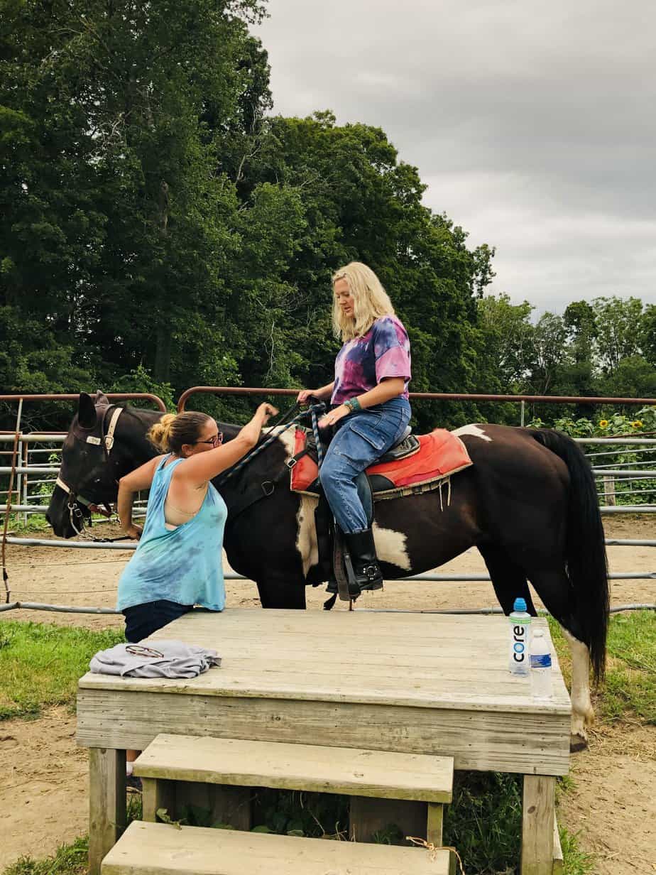 Woman wearing tye-dye on horse at Mountainside Treatment Center Alumni Blazing Saddles horseback riding Event 2021