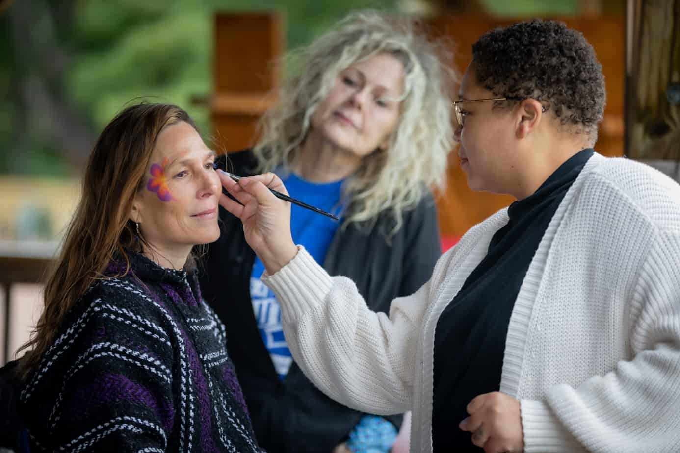 A woman getting her face painted at the Mountainside addiction treatment center alumni reunion 2022.