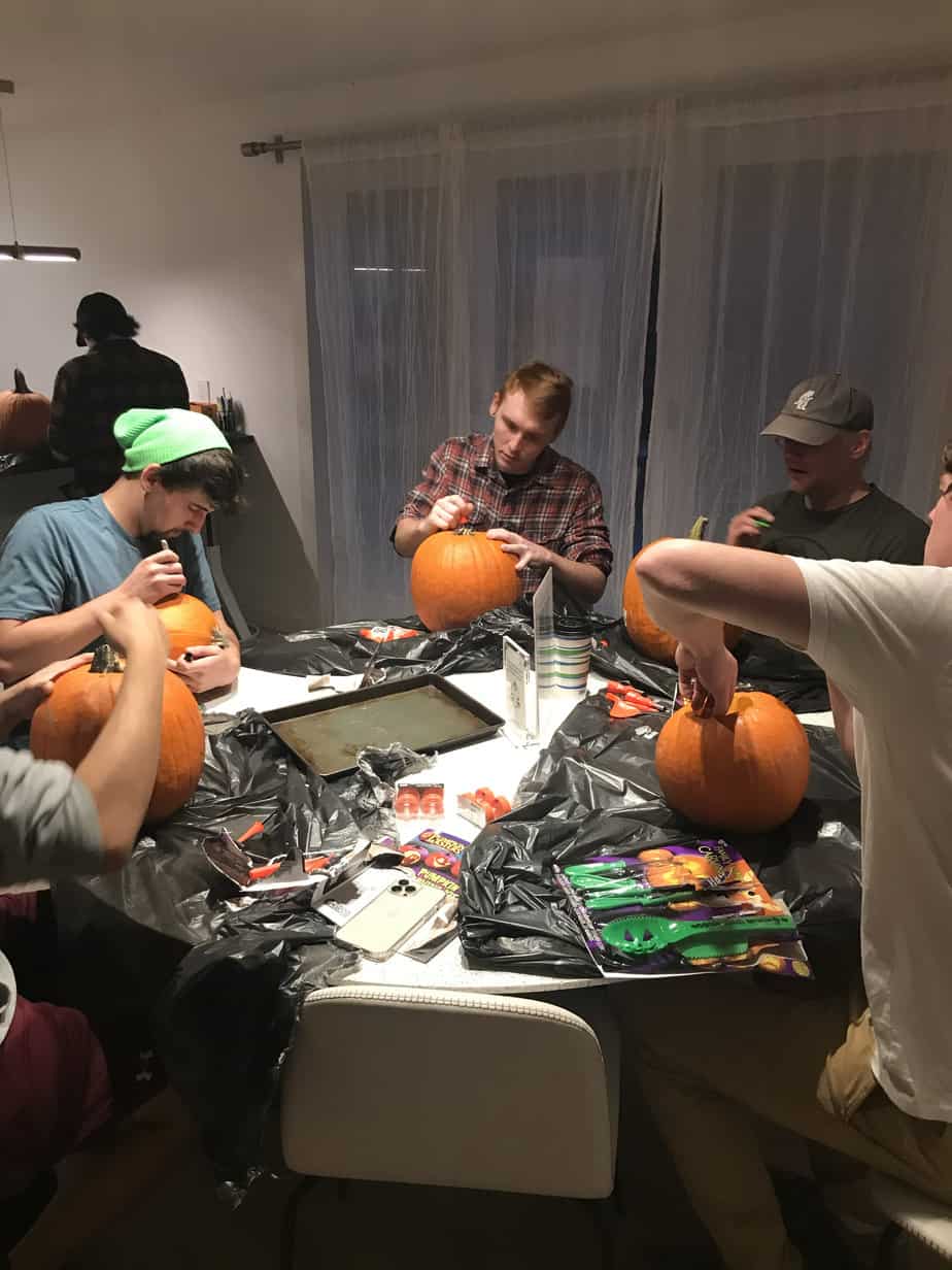 Group of men carving pumpkins around table at Mountainside Treatment Center Extended Care Jack-O-Lantern Carving Event October 2021
