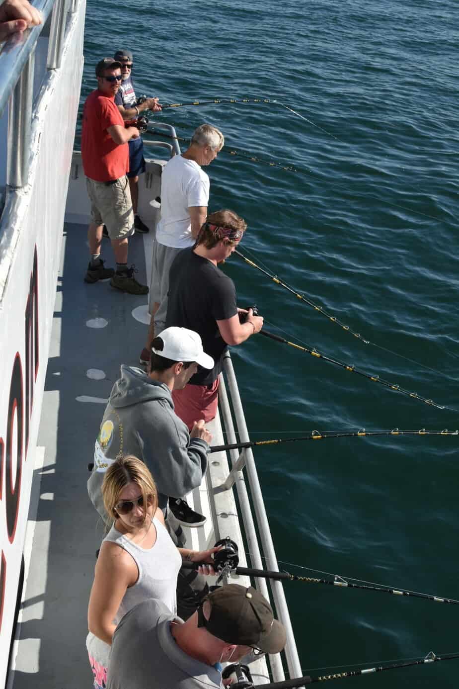 Group photo of team fishing with fishing rods over ocean on boat at Mountainside Treatment Center Extended Care Fishing Event September 2022