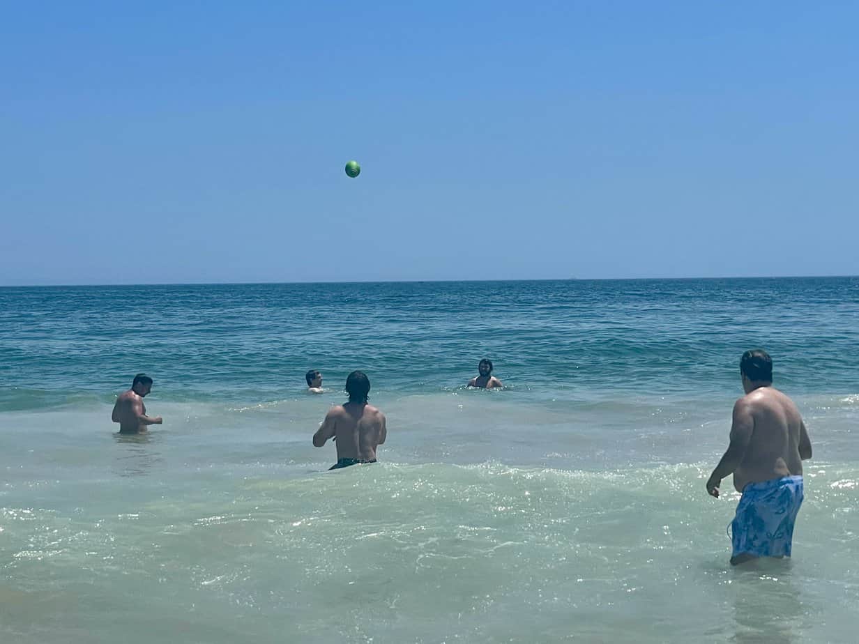 Men playing volleyball in the ocean at Mountainside Treatment Center Extended Care Watch Hill Beach Event July 2021