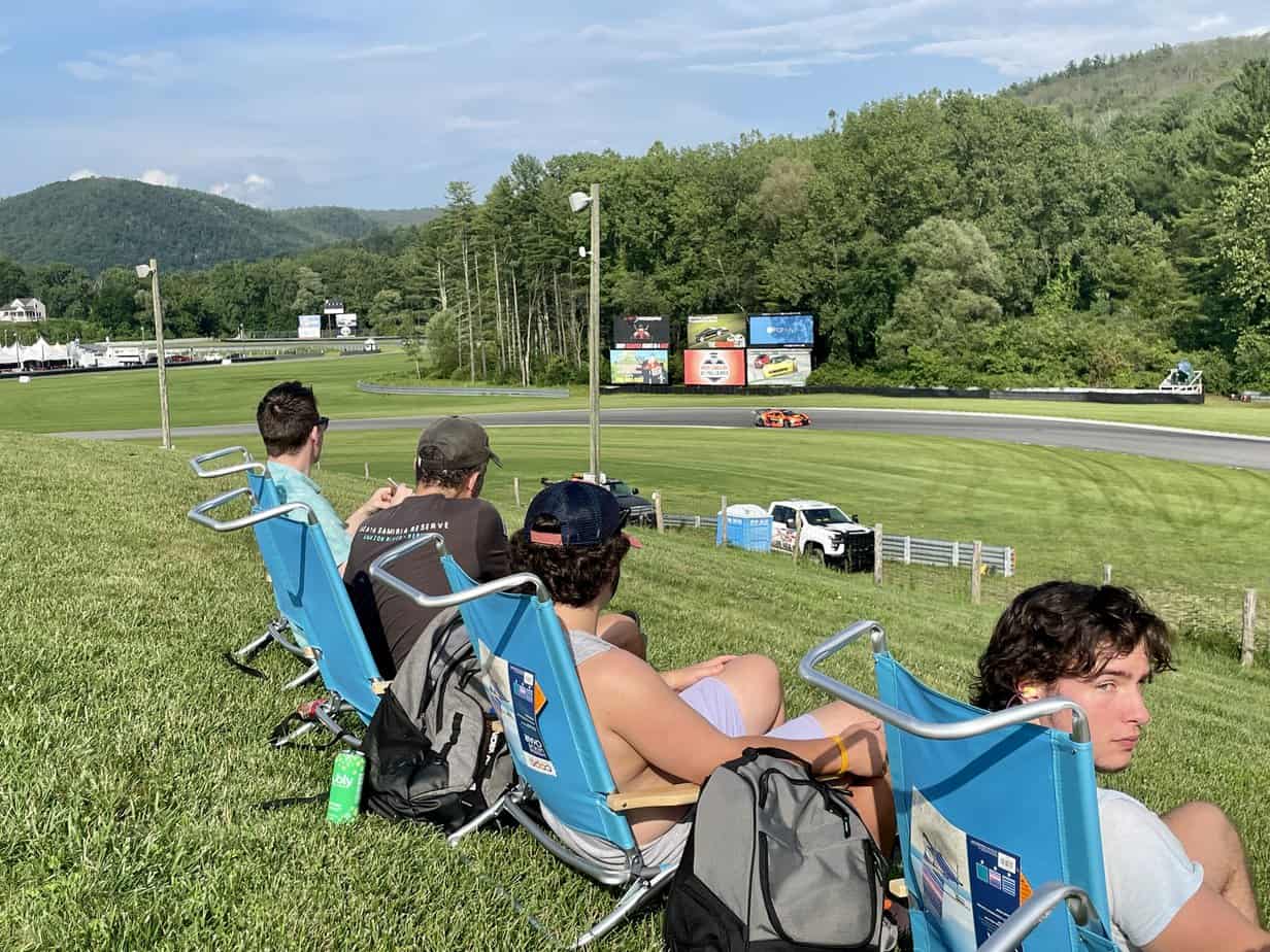 Group photo of men watching race cars on lawn chairs at Mountainside Treatment Center Extended Care Lime Rock Park Event Summer 2022