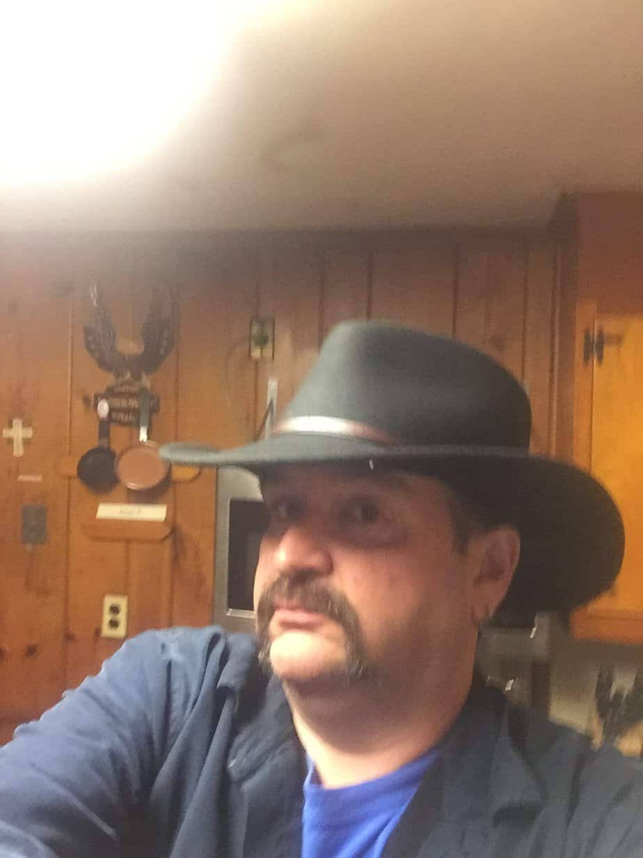 older man wearing cowboy hat in living room