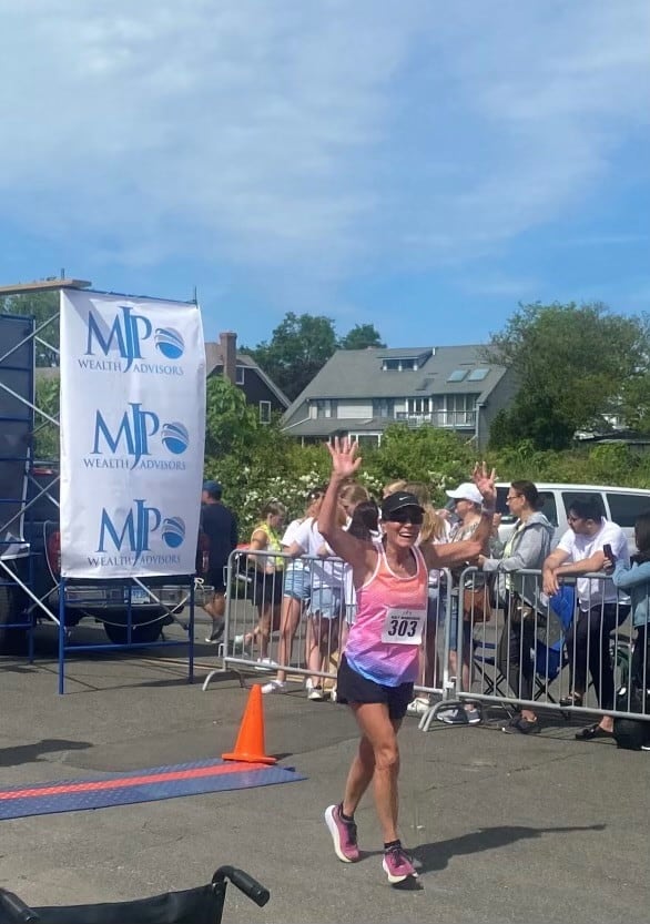 grinning woman completing marathon race