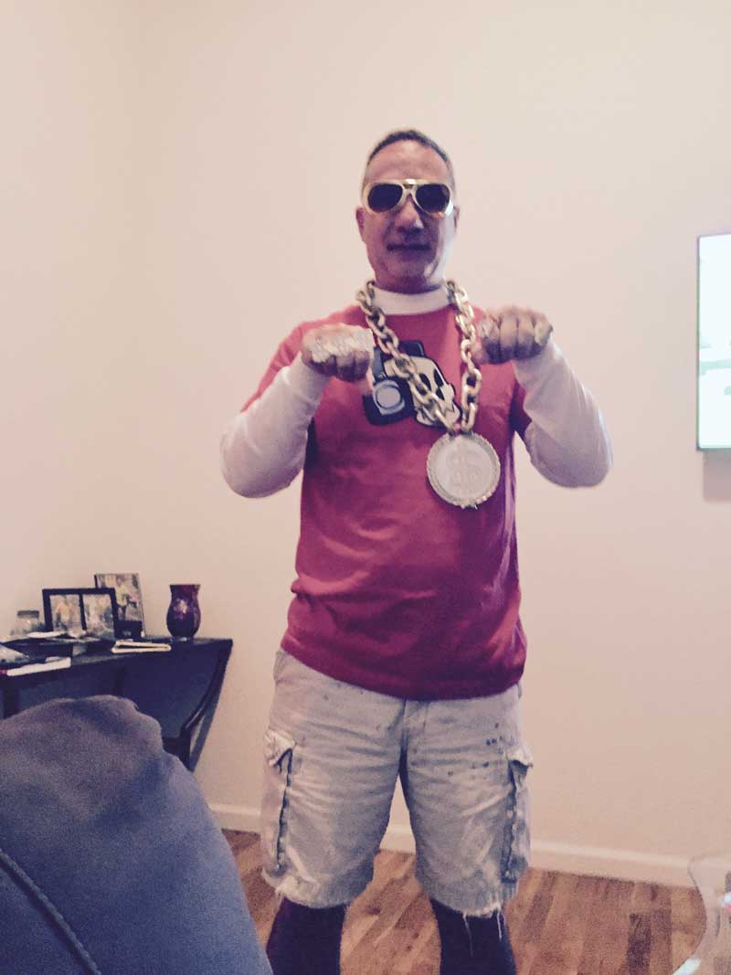 man in sunglasses holding up large gold medallion