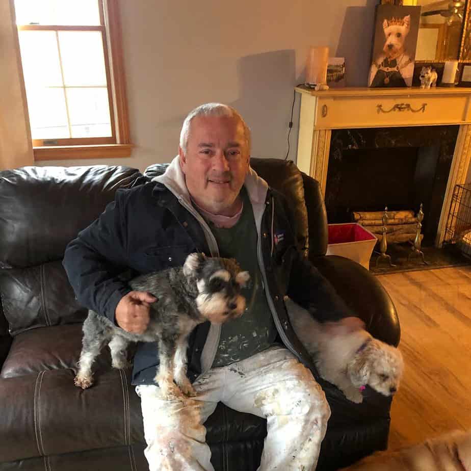 Older Man with dog sitting in couch in living room
