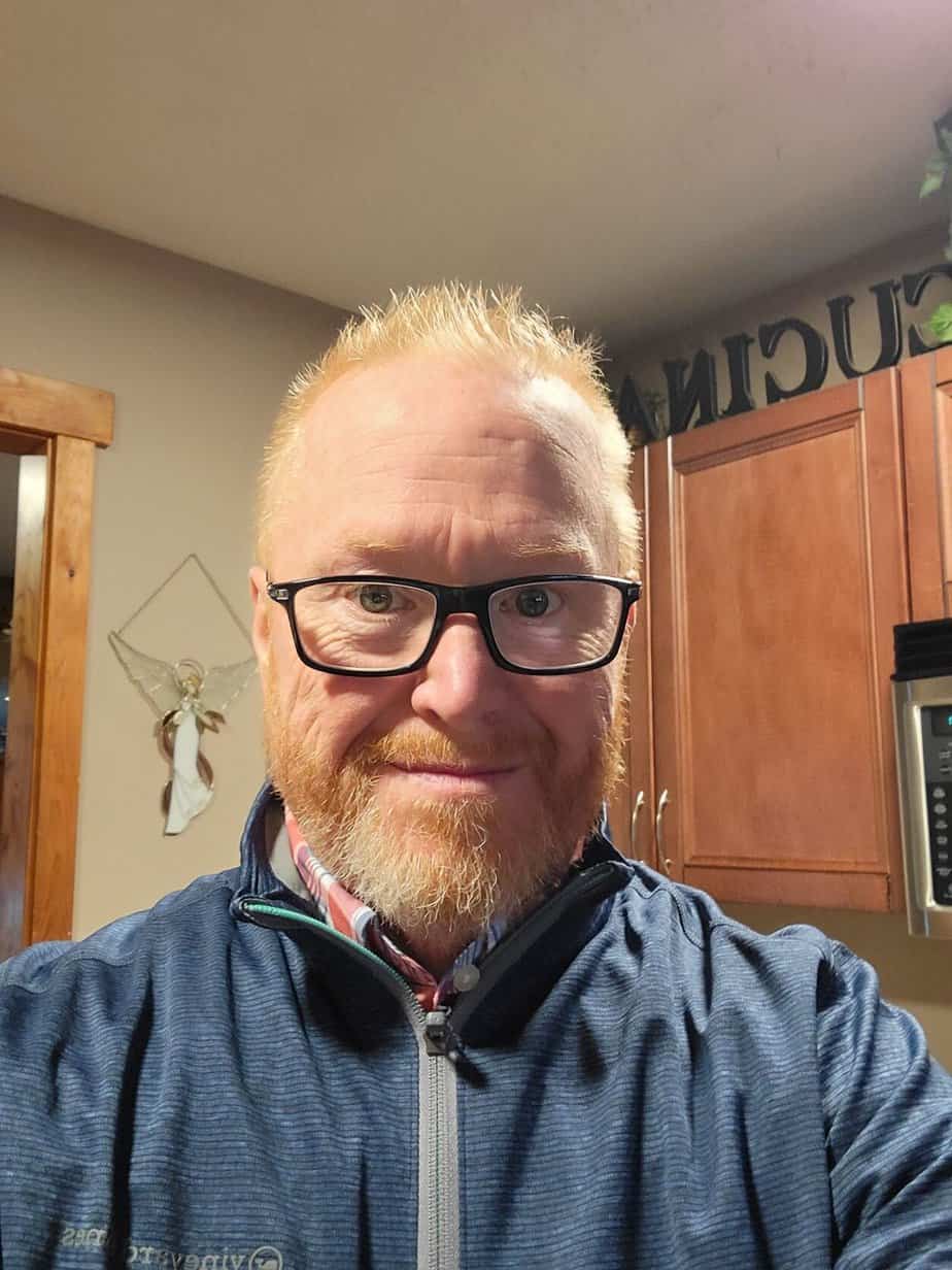 man in glasses takes selfie in kitchen