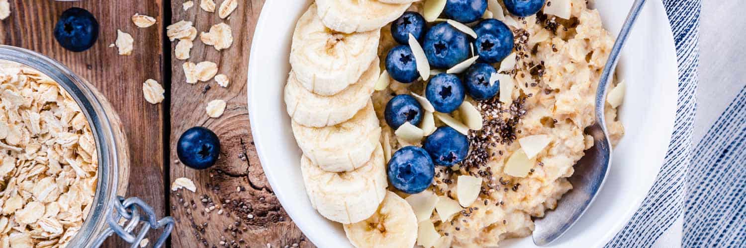 healthy bowl with yogurt, granola, banana slices, and blueberries
