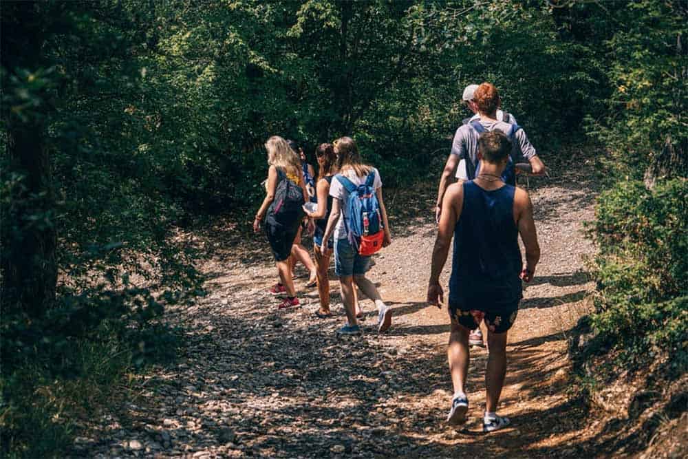 family hikes together along forest trail