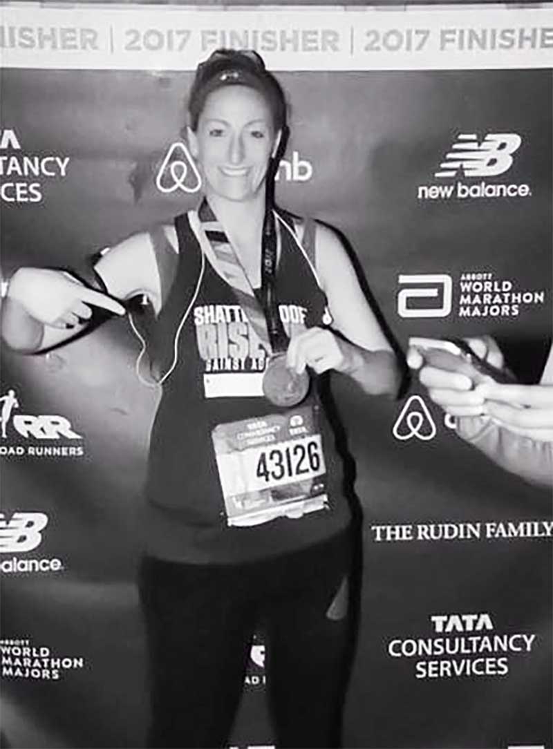 b&w image of woman with medal celebrating athletic achievement