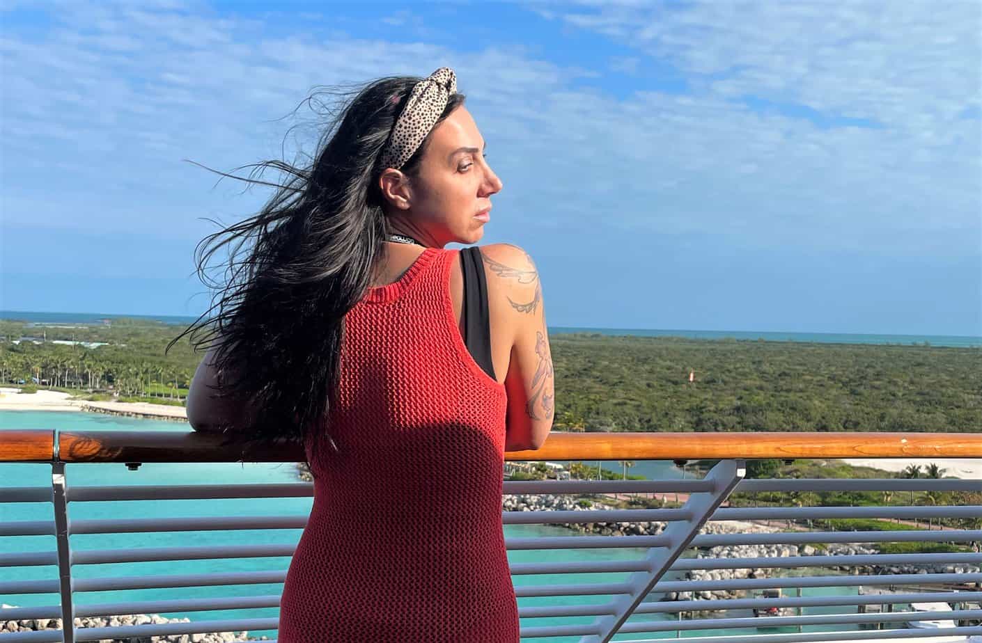 middle aged woman overlooking water on cruise ship