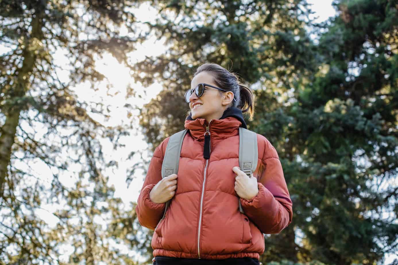 woman with red jacket hiking in the forest