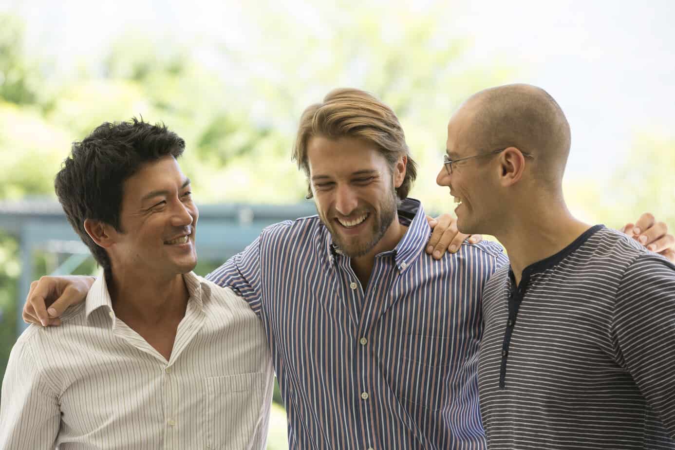 three male friends laughing and having a conversation